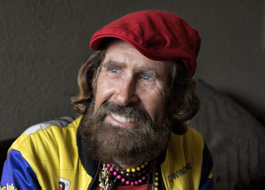 Portret van man met rode baret en gekleude kettingen