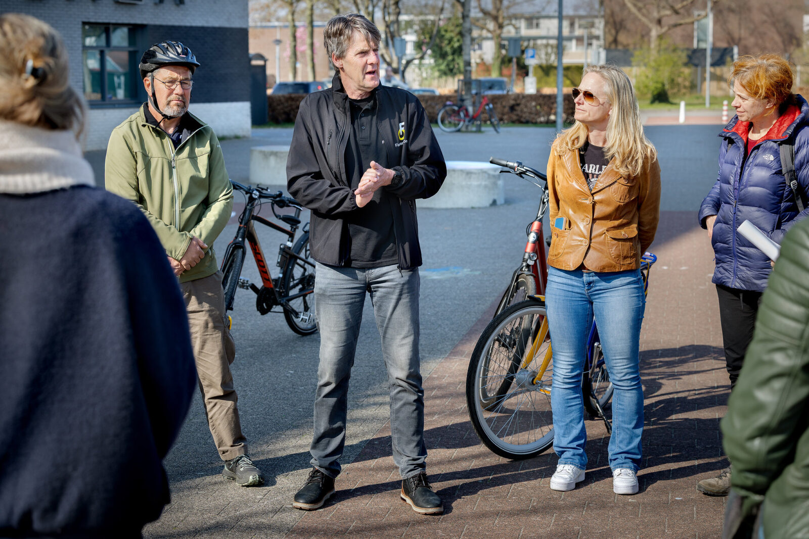 Een fietsdocent geeft uitleg aan een aantal cursisten.